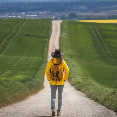 Long journey. Hiking woman walking on empty road